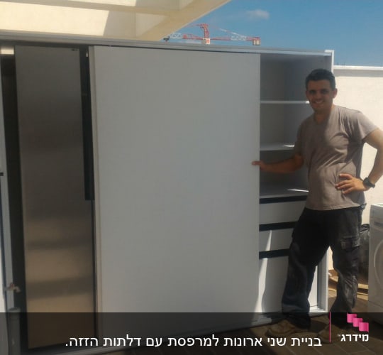 נגר מציג ארון עם דלתות הזזה ומדפים